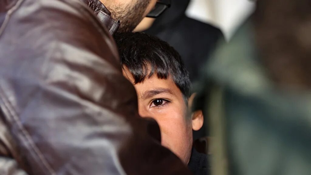 A man comforts a child as people mourn Palestinians killed in an Israeli strike in northern Gaza on 30 November 2024 (Omar al-Qattaa/AFP)
