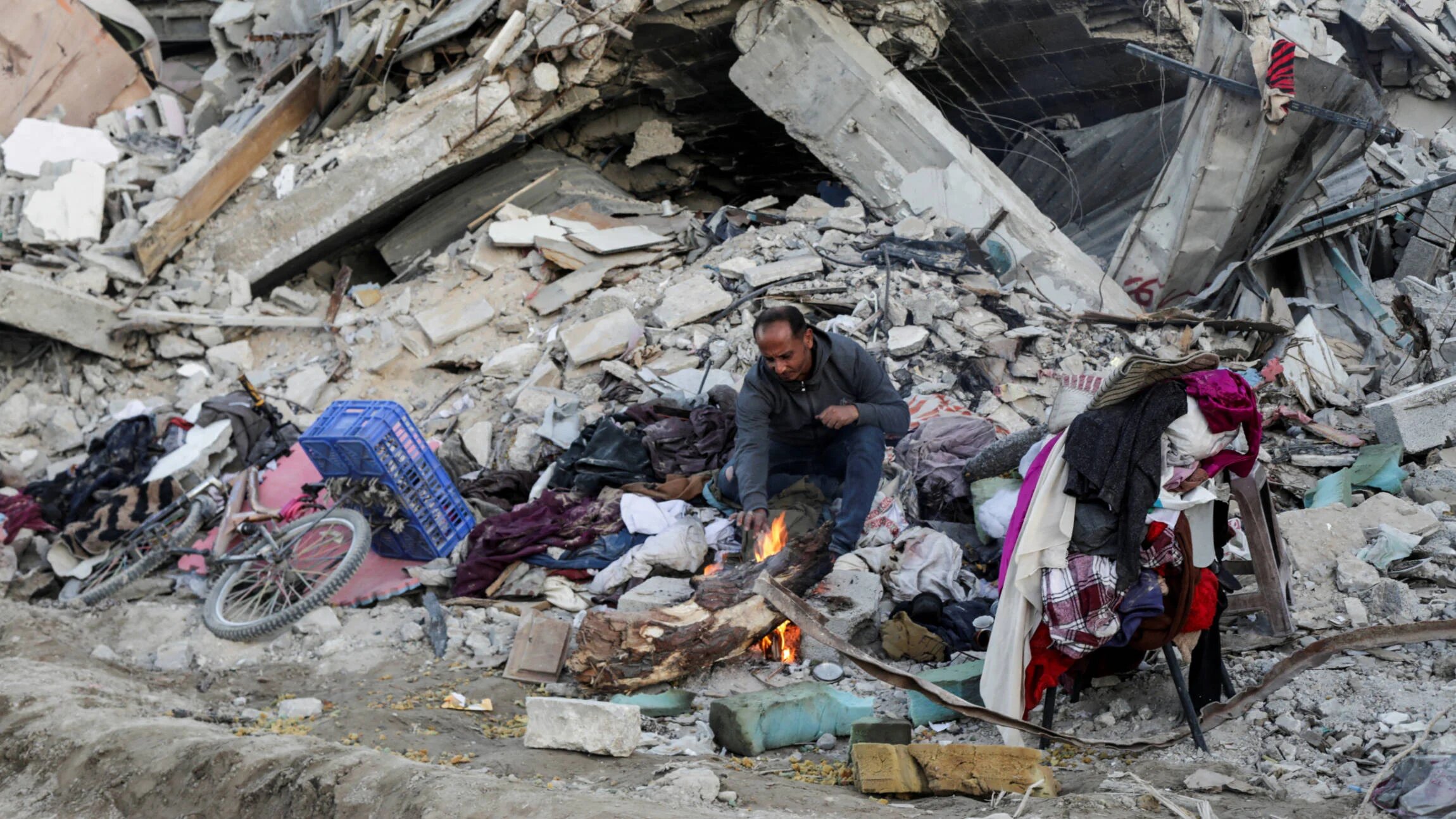 A Palestinian sits near destroyed homes, amid a ceasefire between Israel and Hamas, in Jabalia refugee camp, northern Gaza Strip on 20 January 2025 (Reuters/Mahmoud Issa)