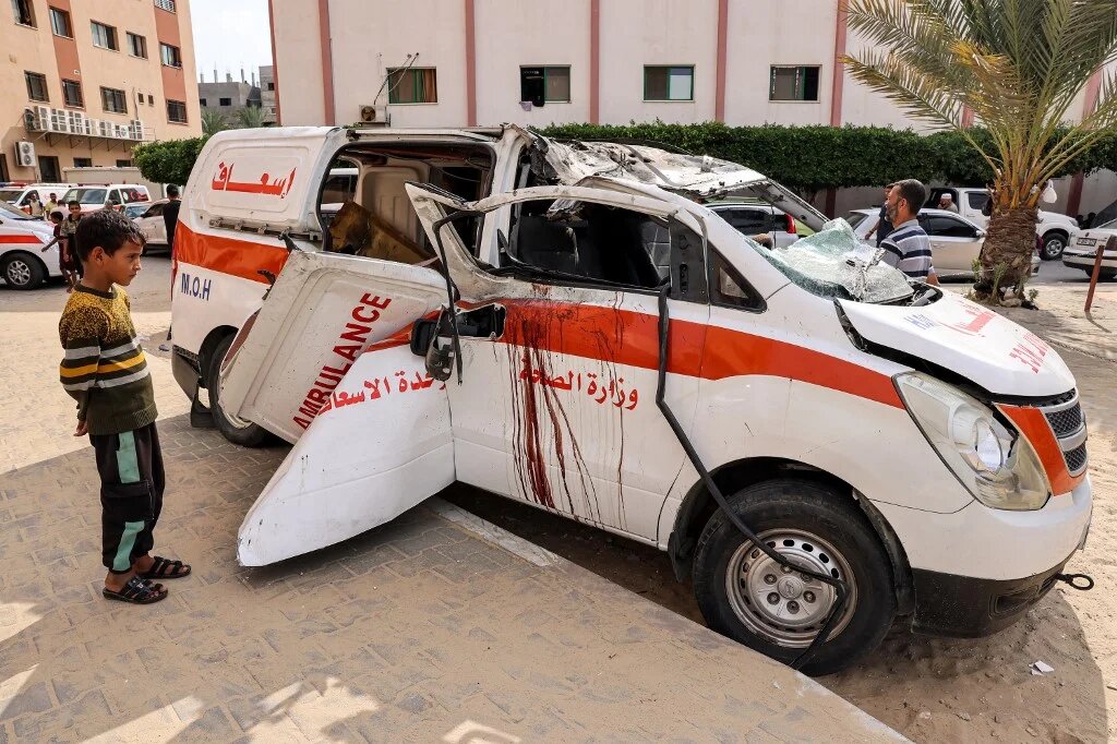 Un enfant regarde une ambulance détruite garée dans une rue de Khan Younès, dans le sud de la bande de Gaza, le 11 octobre 2023 (AFP/Said Khatib)