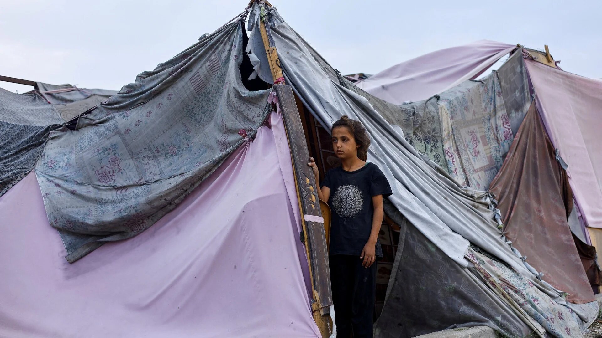 A displaced Palestinian girl looks out of a tent amid a ceasefire between Israel and Hamas, in Gaza City, 4 November 2025. (Reuters/Mahmoud Issa)