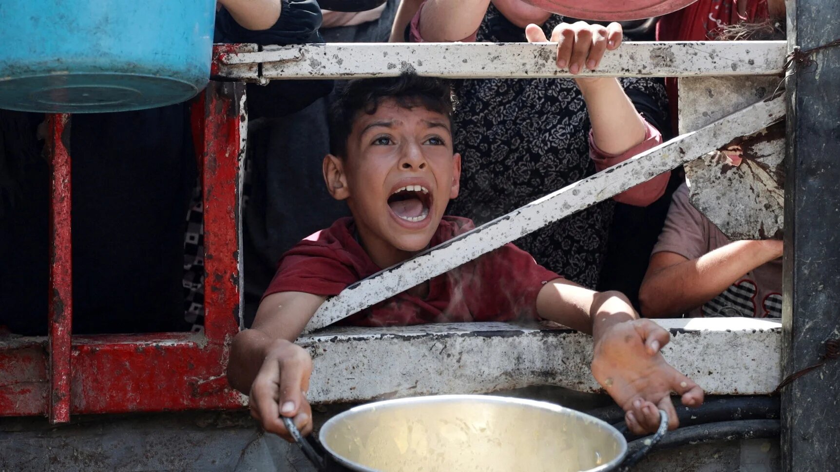 A Palestinian reacts as he waits to receive food from a charity kitchen, amid a hunger crisis, in Gaza City, 28 July 2025 (Reuters/Khamis Al-Rifi)