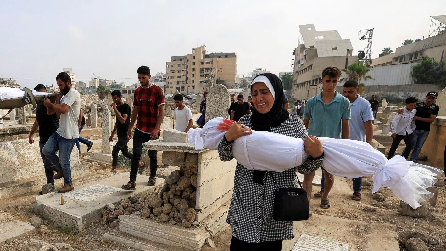 Palestinian woman Soha Tafesh carries the body of her granddaughter Sarah Abu Daf, who was killed in an early morning Israeli strike on a house at a cemetery in Gaza City, 13 August 13, 2025(Reuters/Dawoud Abu Alkas)