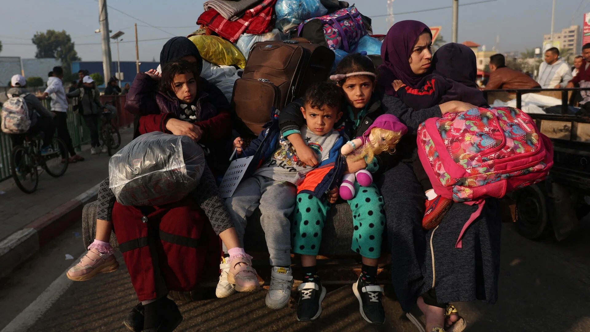Women with children sit in a trailer, as Palestinians flee their houses due to Israeli strikes, after a temporary truce between Hamas and Israel expired, in the eastern part of Khan Younis in the southern Gaza Strip, December 1, 2023 (Reuters)