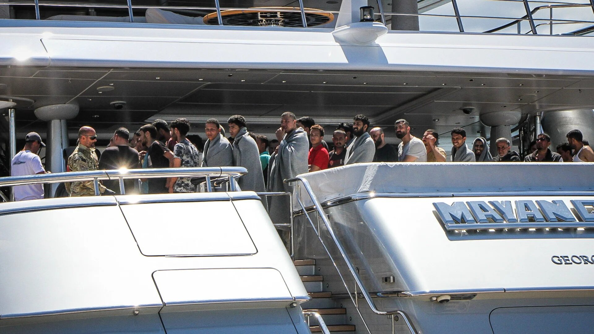 Survivors arrive to the port of Kalamata, after a boat carrying dozens of migrants sank in international waters in the Ionian Sea on 14 June 2023 (AFP)