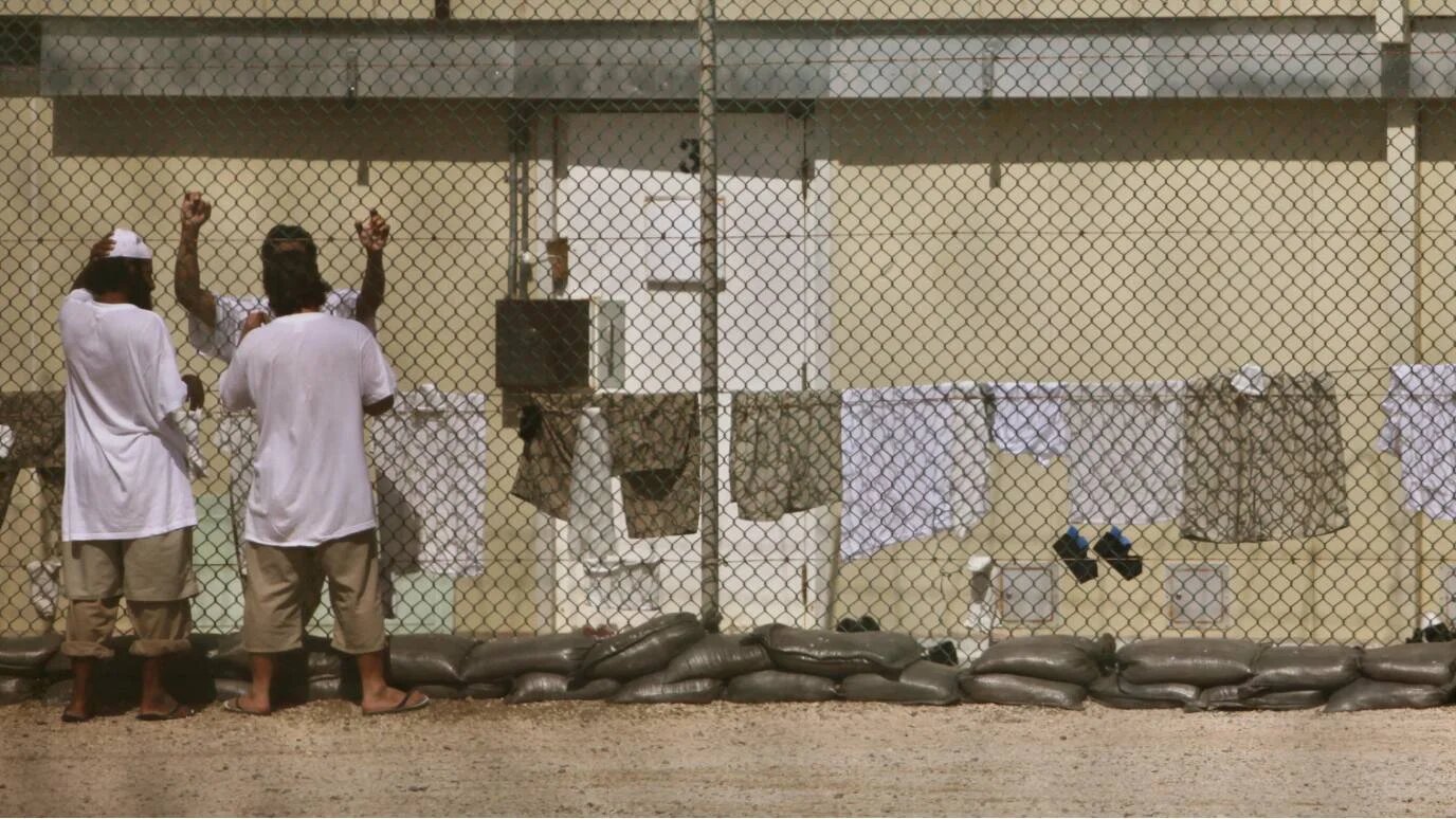 In this pool photo, reviewed by the US military, Guantanamo detainees talk together inside the open-air yard at Camp 4 detention facility at Guantanamo Bay, Cuba on 31 May 2009.