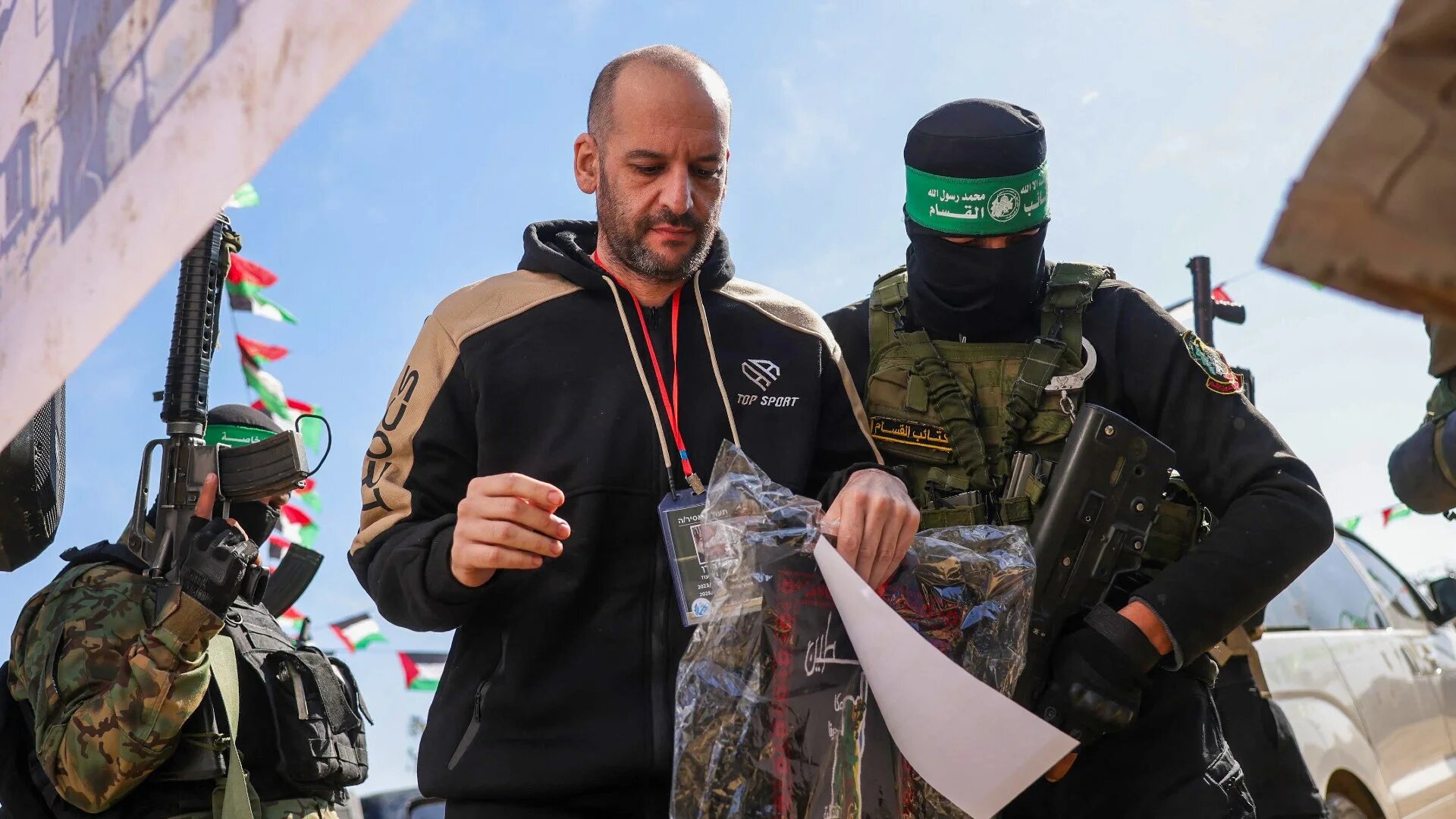 Hamas fighters escort Israeli-Argentinian captive Yair Horn onto a stage before handing him over to a Red Cross team in Khan Yunis, southern Gaza Strip, on 15 February 2025 (AFP/Bashar Taleb)