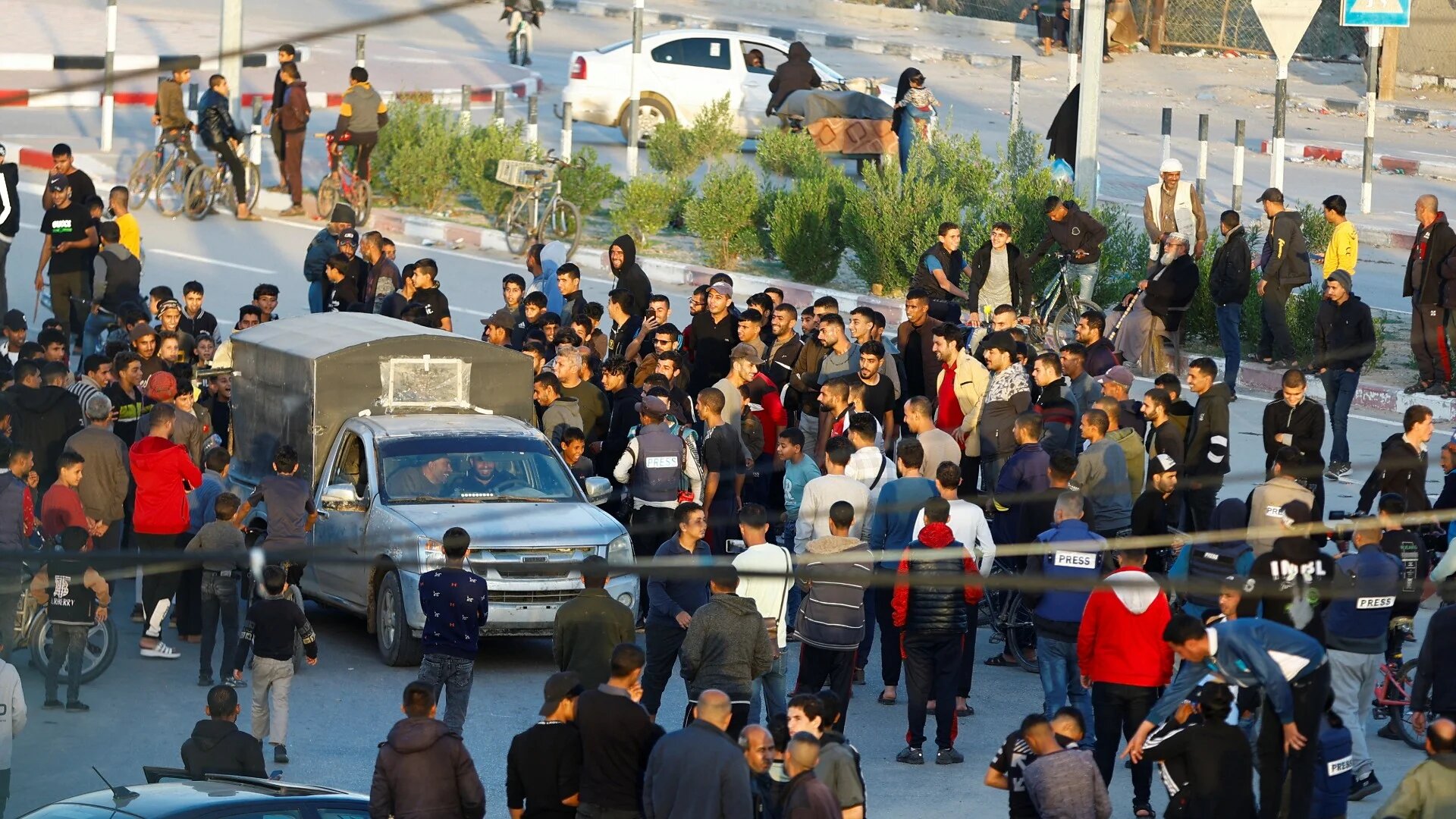 Members of the media and people gather at Rafah border as Hamas release hostages, 24 November 2023 (Reuters)