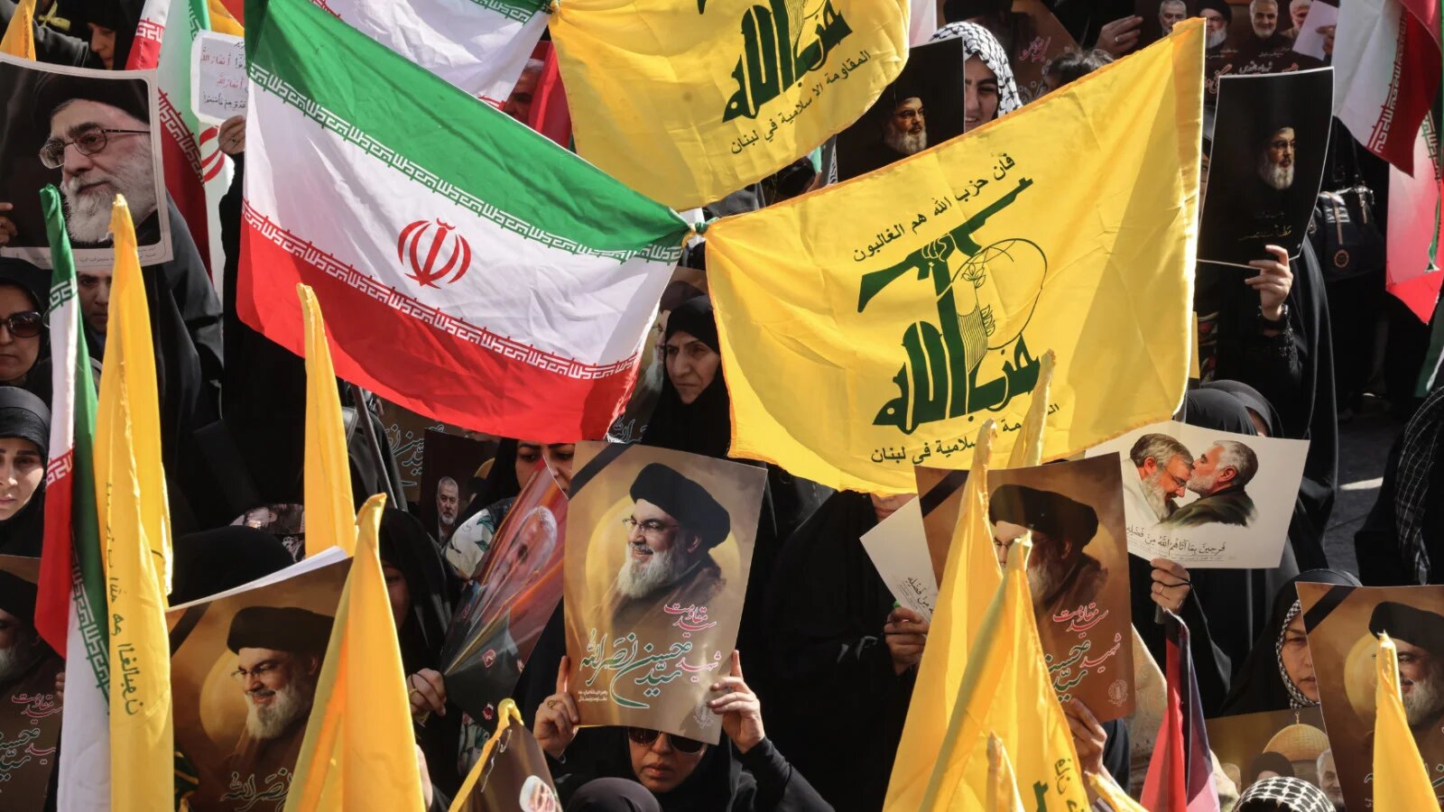 Demonstrators wave flags and carry portraits of slain leaders, including Lebanon's late Hezbollah chief Hassan Nasrallah (C), during a rally in Tehran on 2 October 2024 (AFP)