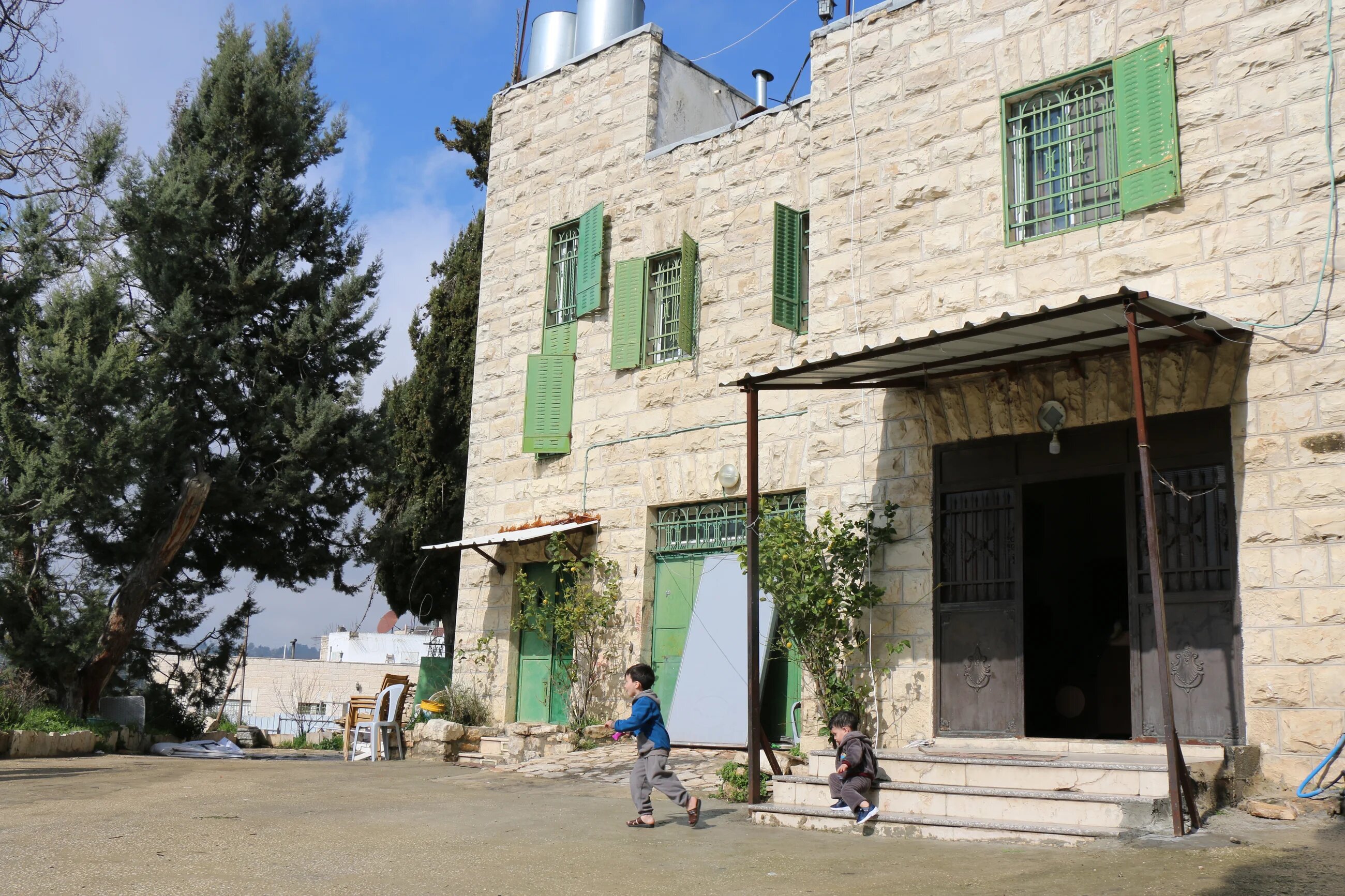 Abu Srour's two young boys play in front of the family home in the exact spot where settlers attacked their father days before (MEE/Akram al-Wa'ara)