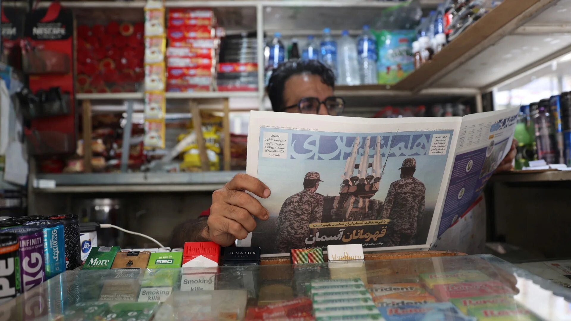 A man reads a newspaper at a newsstand in Tehran, 22 June (Majid Asgaripour/WANA via Reuters)