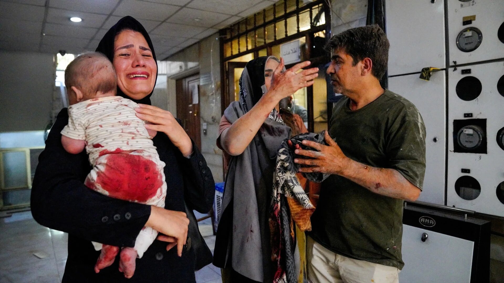 A woman carries her child following the Israeli strikes on the Iranian capital Tehran on 15 June 2025 (Amir Kholousi/West Asia News Agency via Reuters)