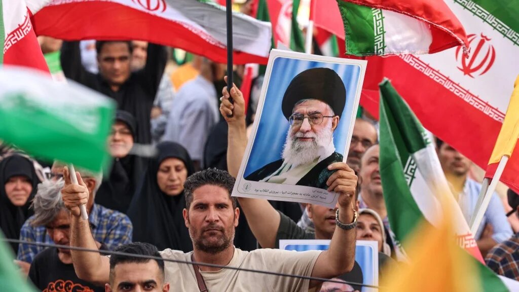 An Iranian man holds a portrait of Supreme Leader Ali Khamenei as people celebrate the ceasefire between Iran and Israel in Tehran on 24 June 2025 (Atta Kenare/AFP)