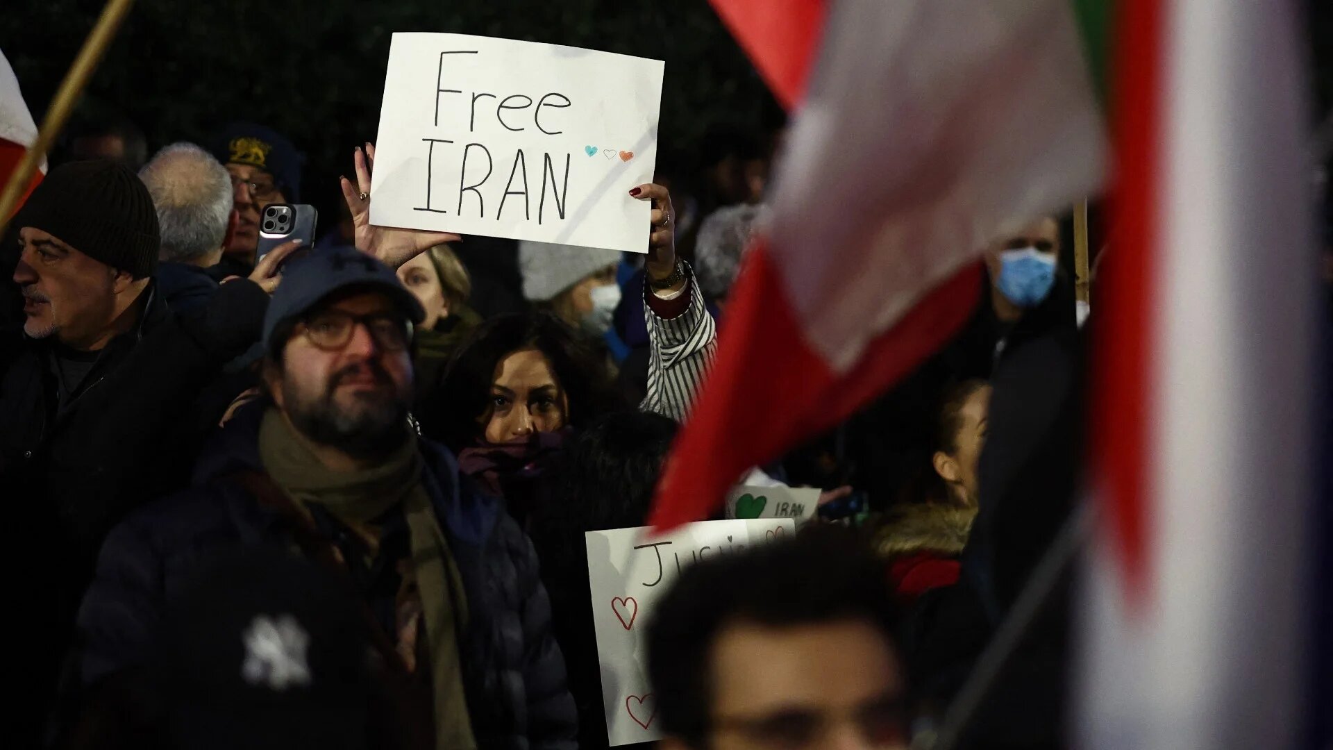 A protester holds up a "Free Iran" placard during a gathering outside the Iranian Embassy, central London, on 9 January 2026 (AFP/Henry Nicholls)