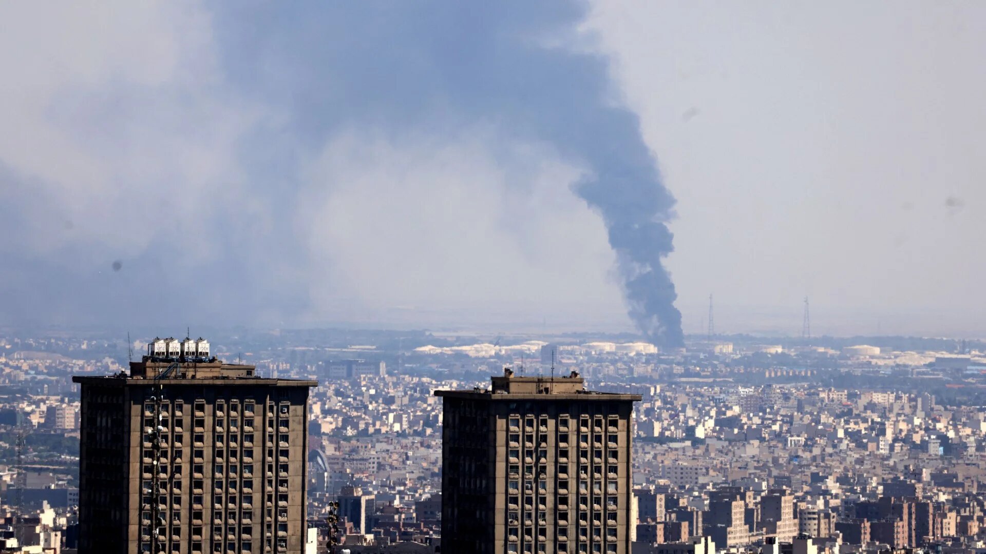 Smoke billows in the distance from an oil refinery following an Israeli strike on the Iranian capital Tehran on 17 June 2025 (Atta Kenare/AFP)