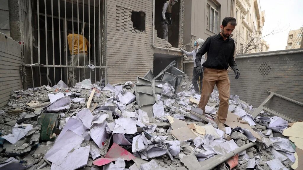 Iranian workers clear debris from a damaged building after a strike on the capital Tehran on 15 March 2026 (Atta Kenare/AFP)