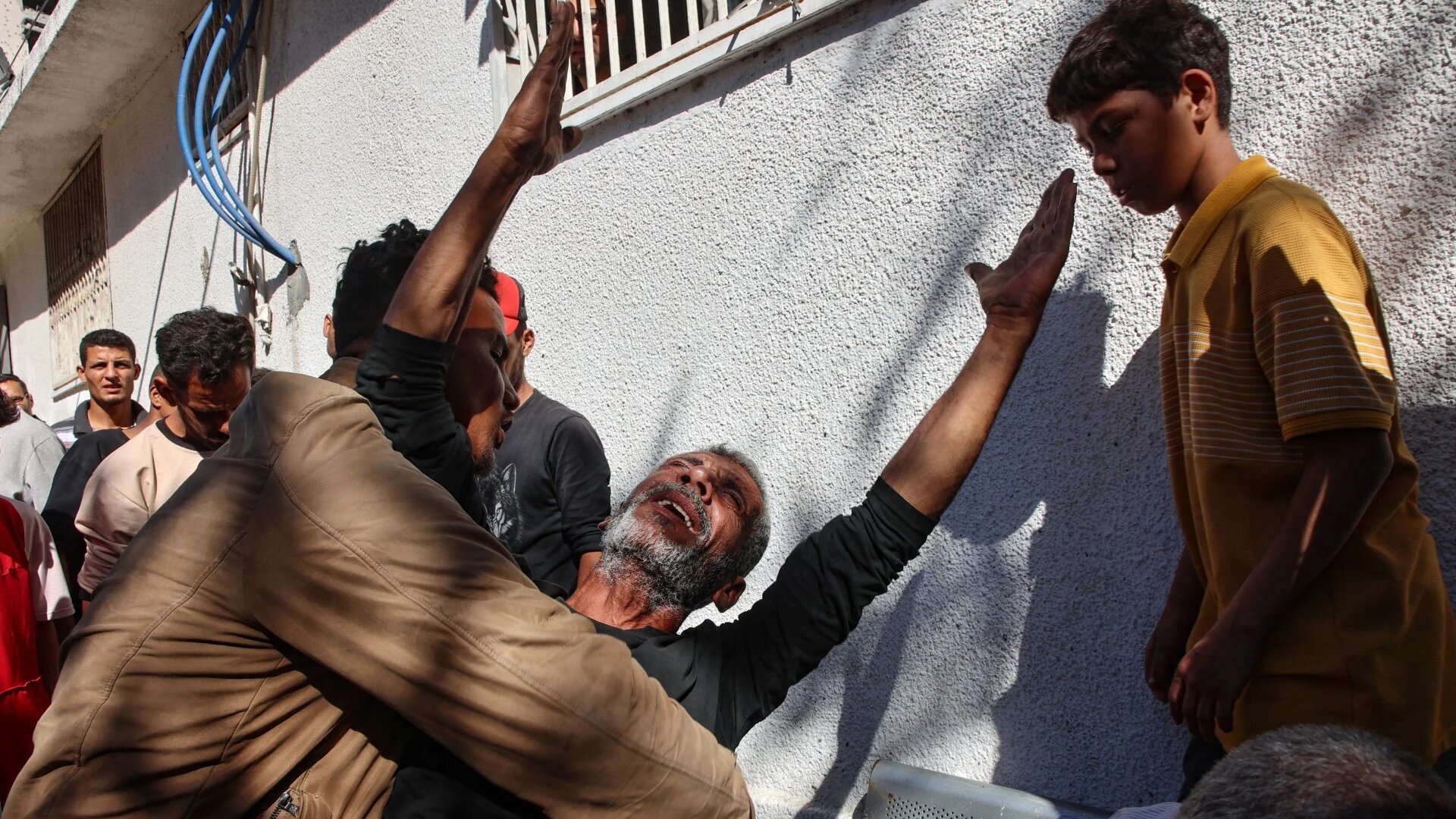 A Palestinian man reacts following an Israeli strike that hit Gaza City's Thai restaurant and its vicinity on 7 May (Omar al-Qattaa/AFP)