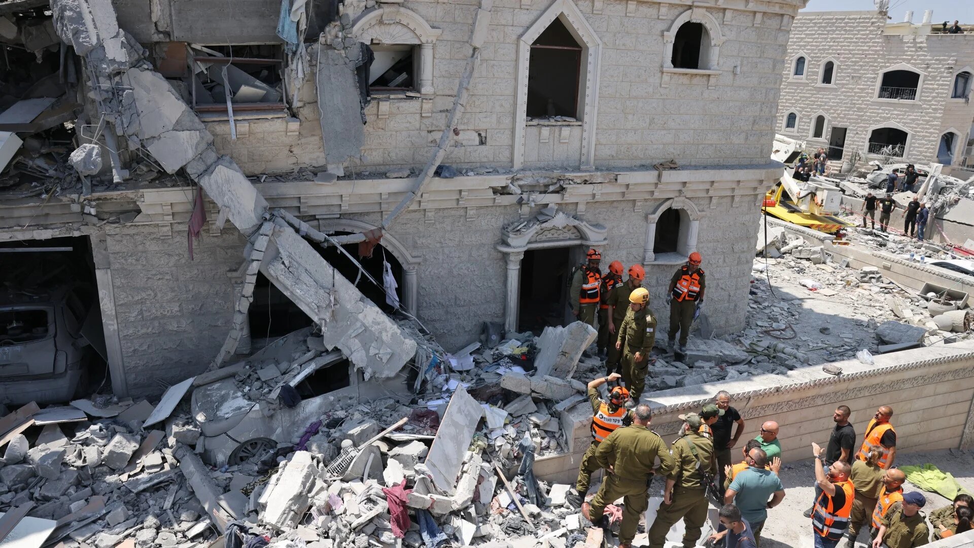 People inspect the rubble of a damaged building in the northern Israeli town of Tamra, following an overnight missile attack from Iran on 15 June 2025 (Ahmad Gharabli/AFP)