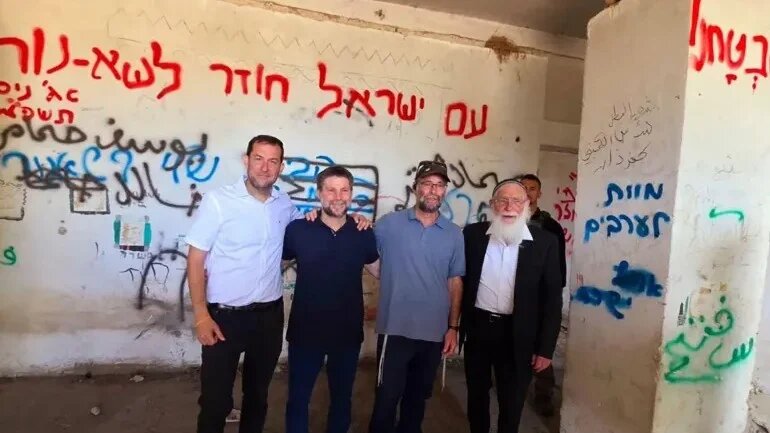 Israeli Finance Minister Bezalel Smotrich can be seen posing near graffiti that called for 'Death to Arabs' on 7 August 2025 (Screengrab)