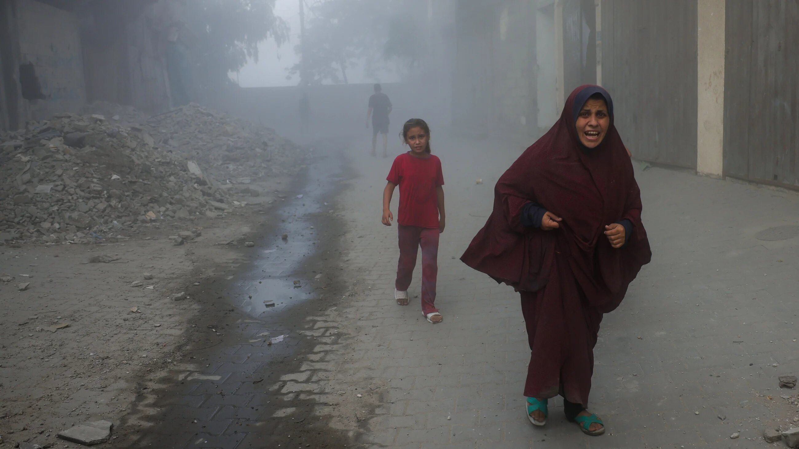 Palestinians run from the site of Israeli strikes on a six-storey building in the Saftawi neighbourhood, west of Jabalia in the northern Gaza Strip, on 19 August 2025 (Bashar Taleb/AFP)