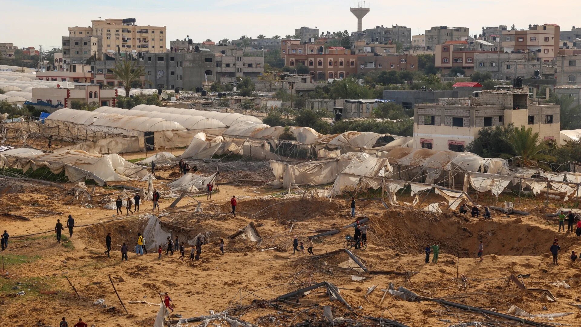 People stand around craters caused by Israeli bombardment in Rafah in the southern Gaza Strip on 12 February 2024 (Said Khatib/AFP)