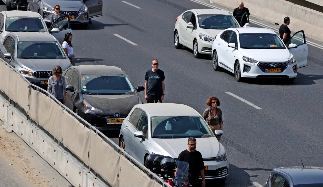Drivers stop and stand in silence beside their vehicles on 28 April 2022 to honour the six million Jews and other victims killed by the Nazis during World War Two (AFP)