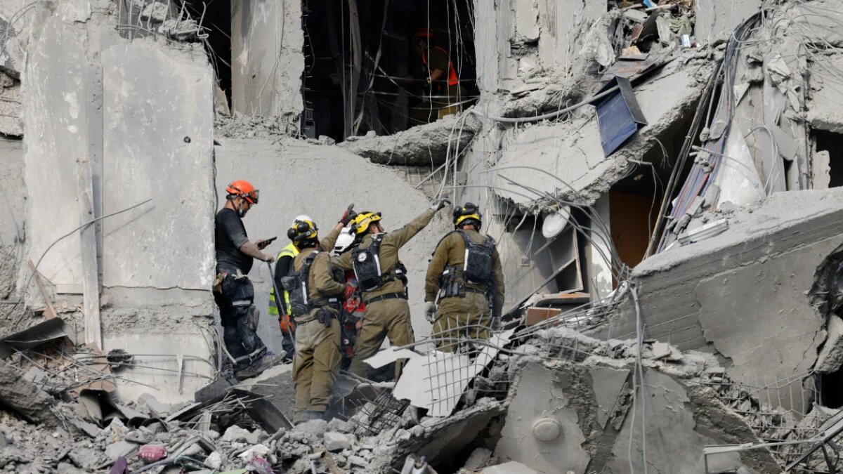 Emergency workers check the damage caused to a building from an Iranian missile strike in Beersheba in southern Israel on 24 June 24 2025 (AFP)