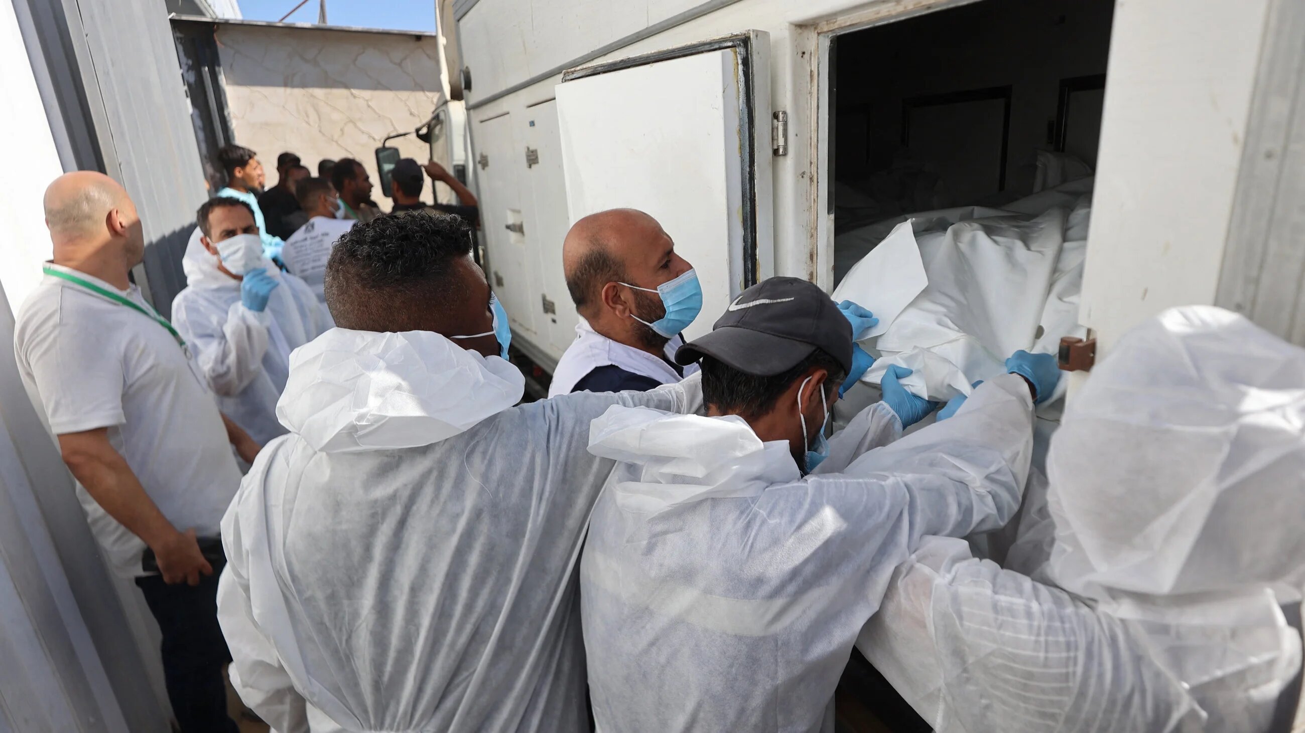 Morgue workers unload the bodies of Palestinians handed over by Israel and transported by Red Crescent vehicles to the Nasser hospital in Khan Younis, southern Gaza Strip on 15 October, 2025 (AFP/Omar al-Qattaa)