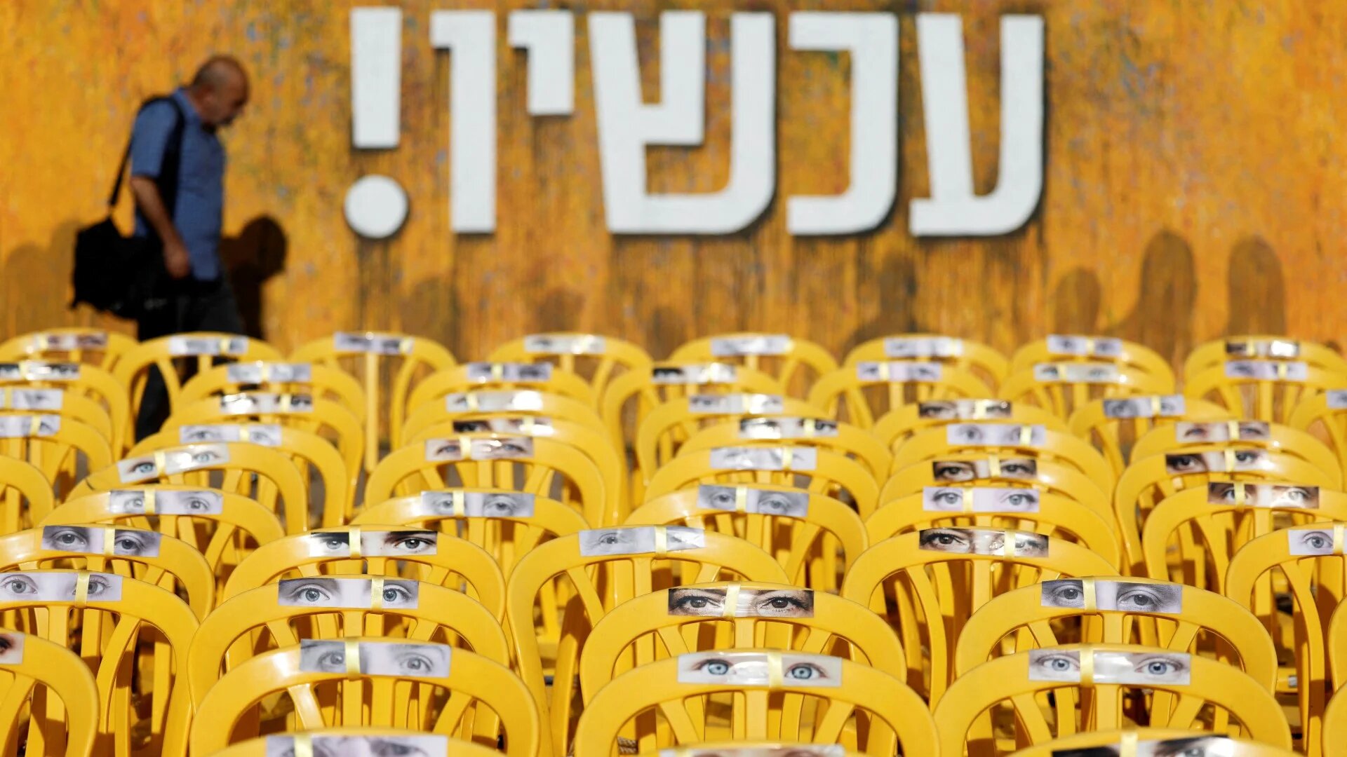 A man walks in front of a sign reading "Now!" in reference to hostages kidnapped during the deadly 7 October attack by Hamas, in Tel Aviv, Israel, 24 September 2024 (Reuters/Amir Cohen)