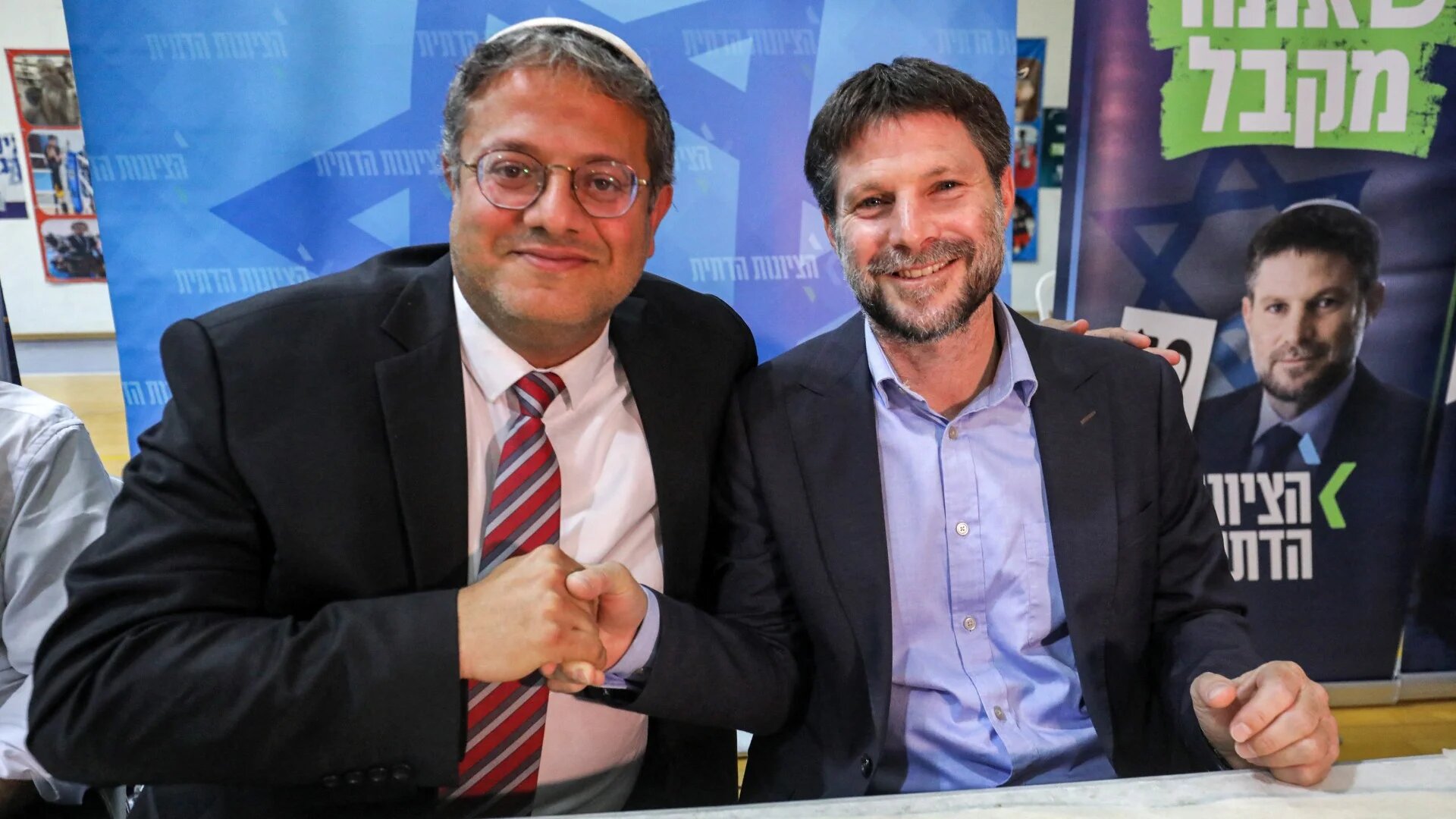 Israeli National Security Minister and leader of the Otzma Yehudit (Jewish power) party Itamar Ben-Gvir (L) and Israeli Finance Minister and leader of the Religious Zionist Party Bezalel Smotrich (R) attend a rally in the Israeli city of Sderot on 26 October 2022 (Gil Cohen-Magen/AFP)