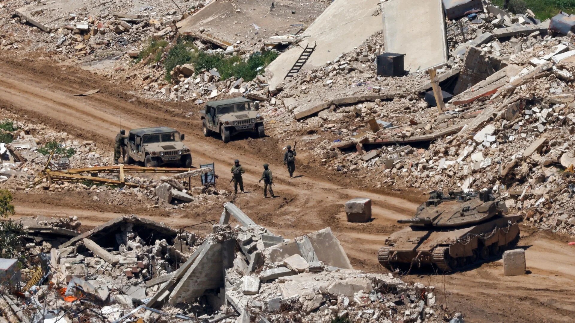 Israeli tanks and military vehicles on a road between destroyed houses in southern Lebanon near the border with northern Israel, on 29 April 2026 (Jalaa Marey/AFP)