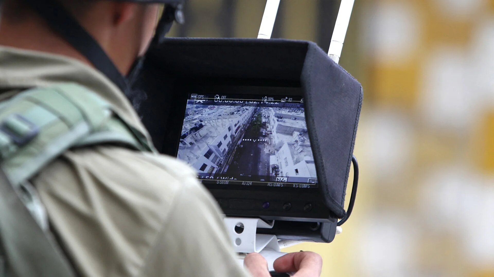 An Israeli soldier uses an unmanned surveillance drone to monitor Palestinians in the occupied West Bank city of Hebron as Israeli settlers visit the holy site of the tomb of Atnaeil Ben Kinaz on 30 September 2015.