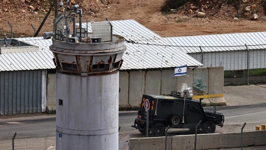 An Israeli military vehicle drives in front of a watchtower inside the Ofer prison complex in the occupied West Bank on 25 January 2025 (Zain Jaafar/AFP)