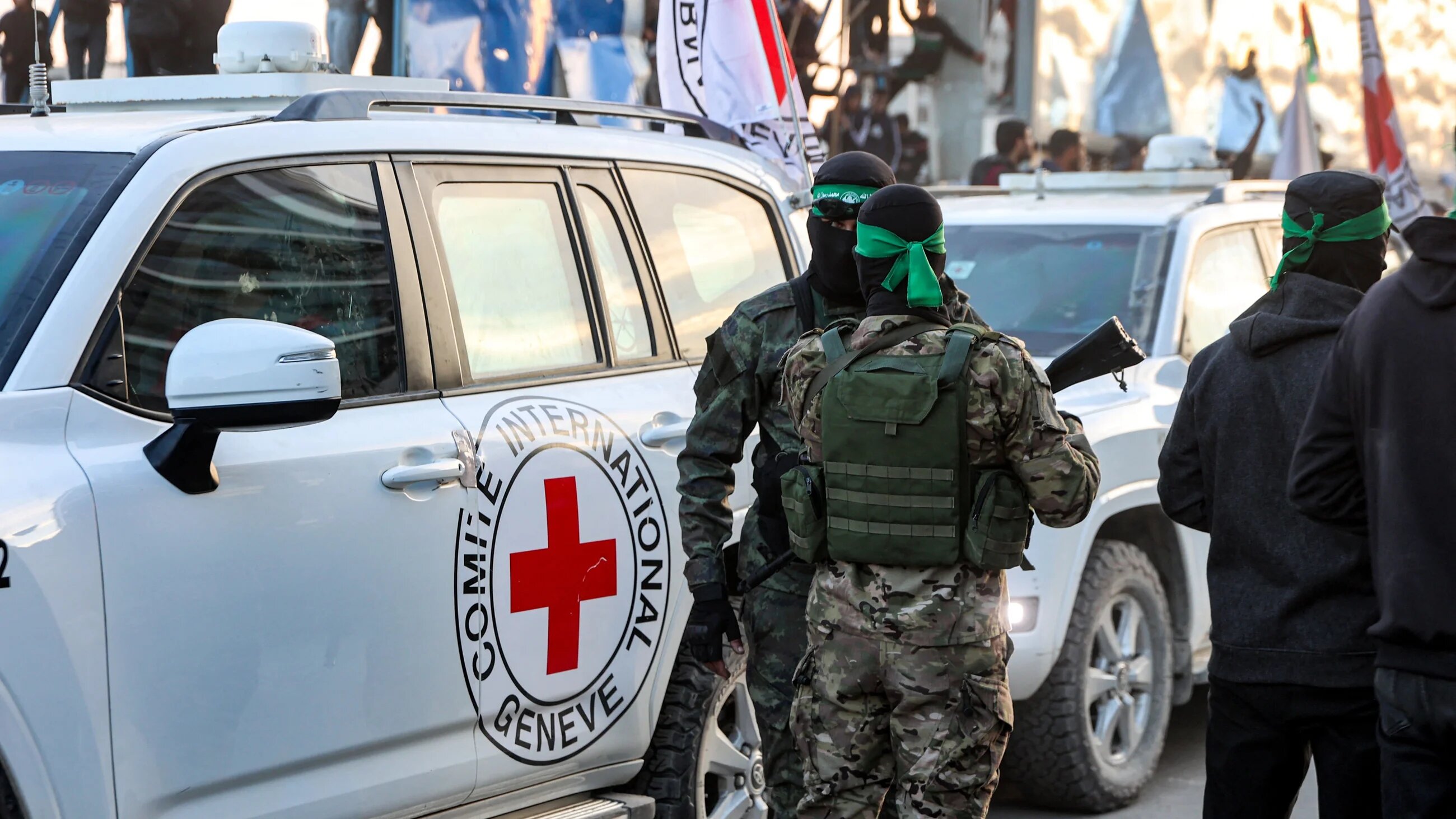 Hamas's armed wing, al-Qassam brigades, stand by vehicles of the International Committee of the Red Cross (ICRC) in Saraya Square, western Gaza City, on 19 January, 2025 (AFP/Omar al-Qattaa)