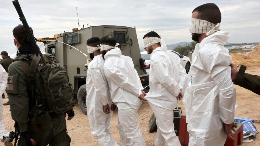 Israeli soldiers transport Palestinian men arrested during a military raid on Jenin, in the occupied West Bank, on 22 January 2025 (Gil Cohen-Magen/AFP)