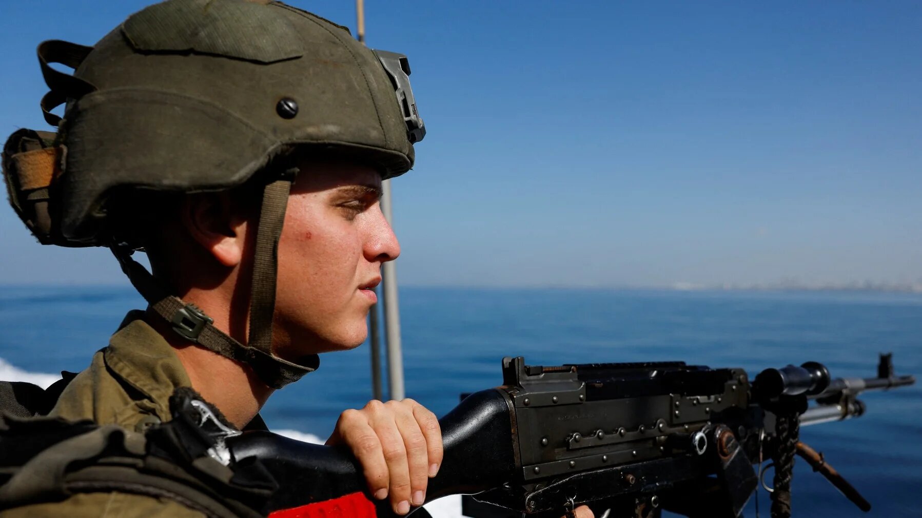 An Israeli soldier stands on a naval ship as it sails on the Mediterranean Sea, amid the ongoing conflict between Israel and Palestinian armed groups, near Israel's border with Gaza in southern Israel, 9 November 2023 (Reuters)