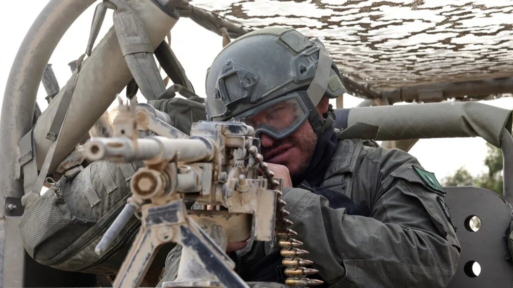 An Israeli soldier sits behind a mounted gun near the Gaza border on 1 May 2024 (Jack Guez/AFP)