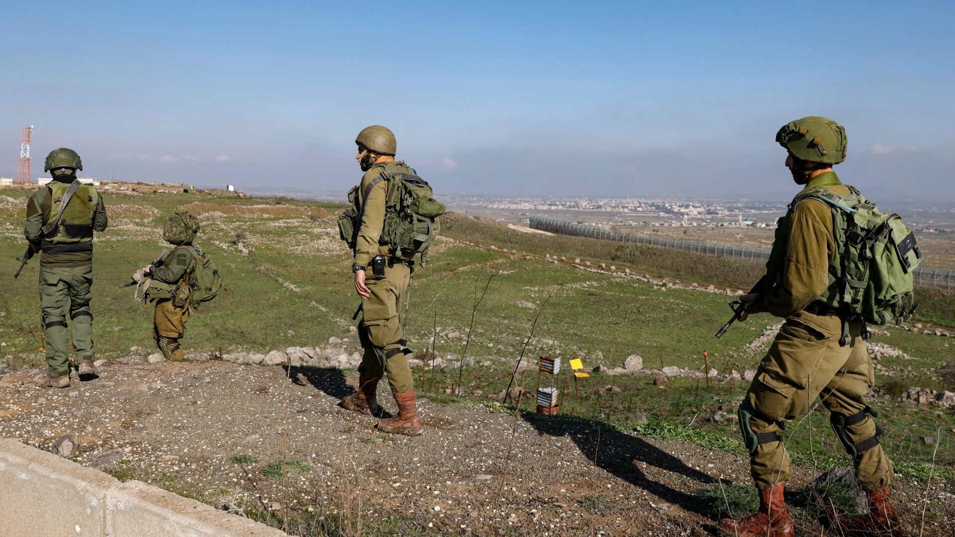 Israeli soldiers walk in a position in the Israeli-occupied Golan Heights on 28 December 2023 (Jalaa Marey/AFP)