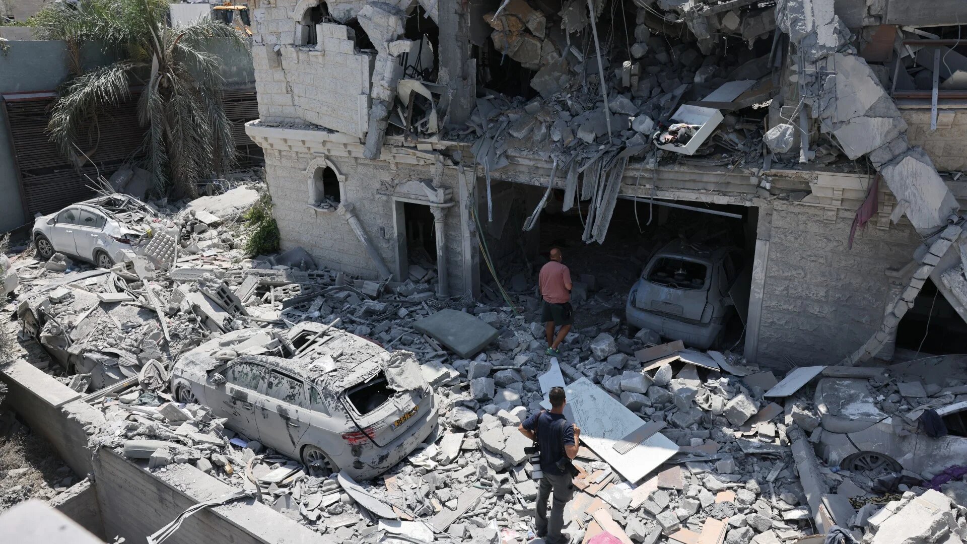 People inspect the rubble of a damaged building in the northern Israeli town of Tamra, following an overnight missile attack from Iran on 15 June 2025 (Ahmad Gharabli/AFP)