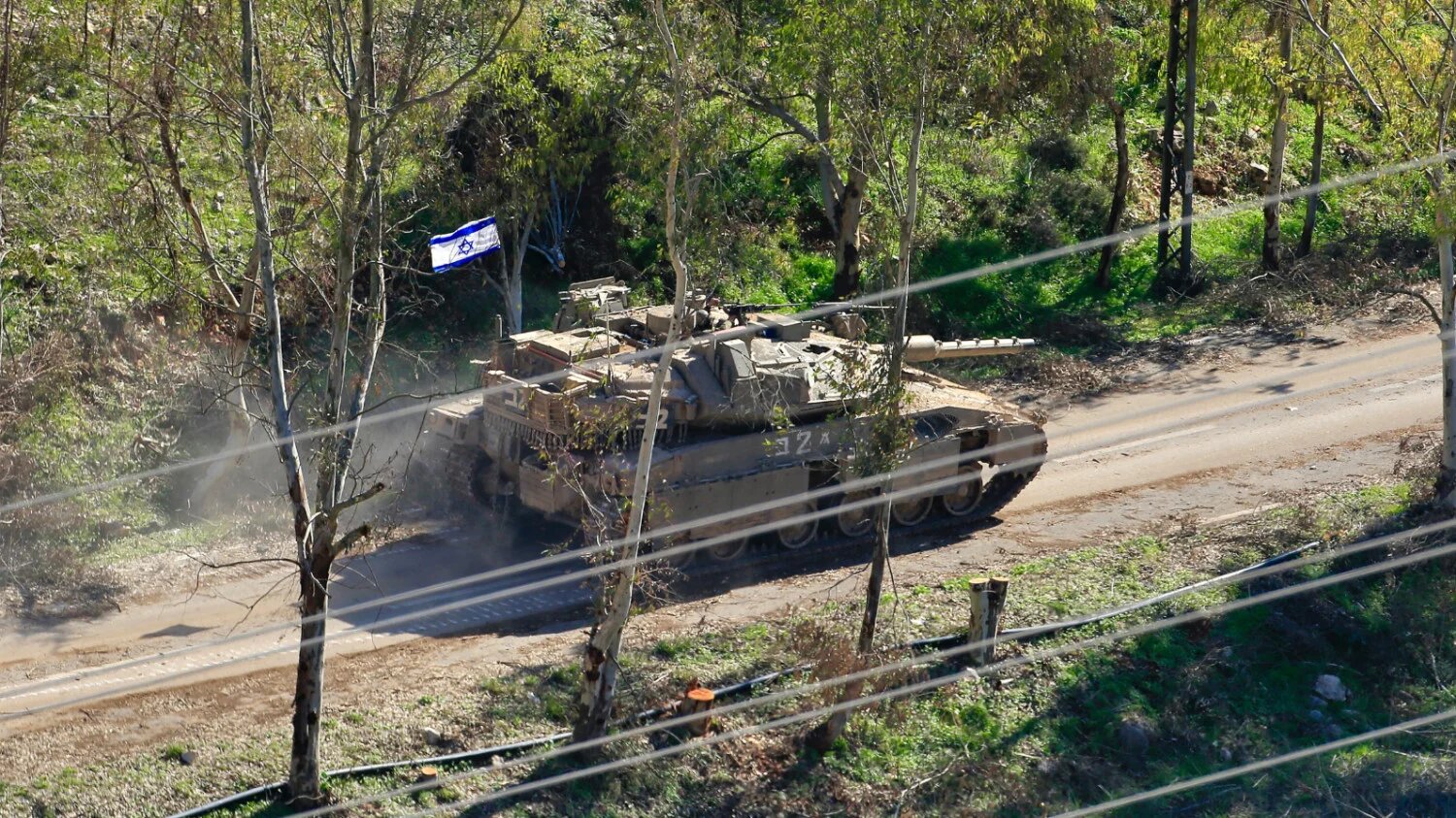 An Israeli army Merkava tank moves along a road on the outskirts of Mais al-Jabal on the border with Israel in south Lebanon on 25 January 2025 (AFP)