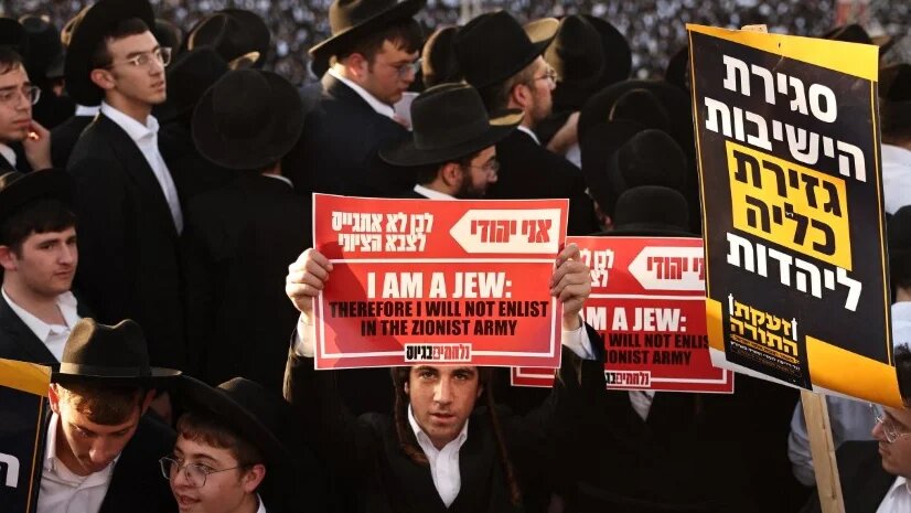 Ultra-Orthodox Jewish protesters hold up placards during a demonstration against conscription into Israel’s military, in Jerusalem on 30 October 2025 (Fadel Senna/AFP)