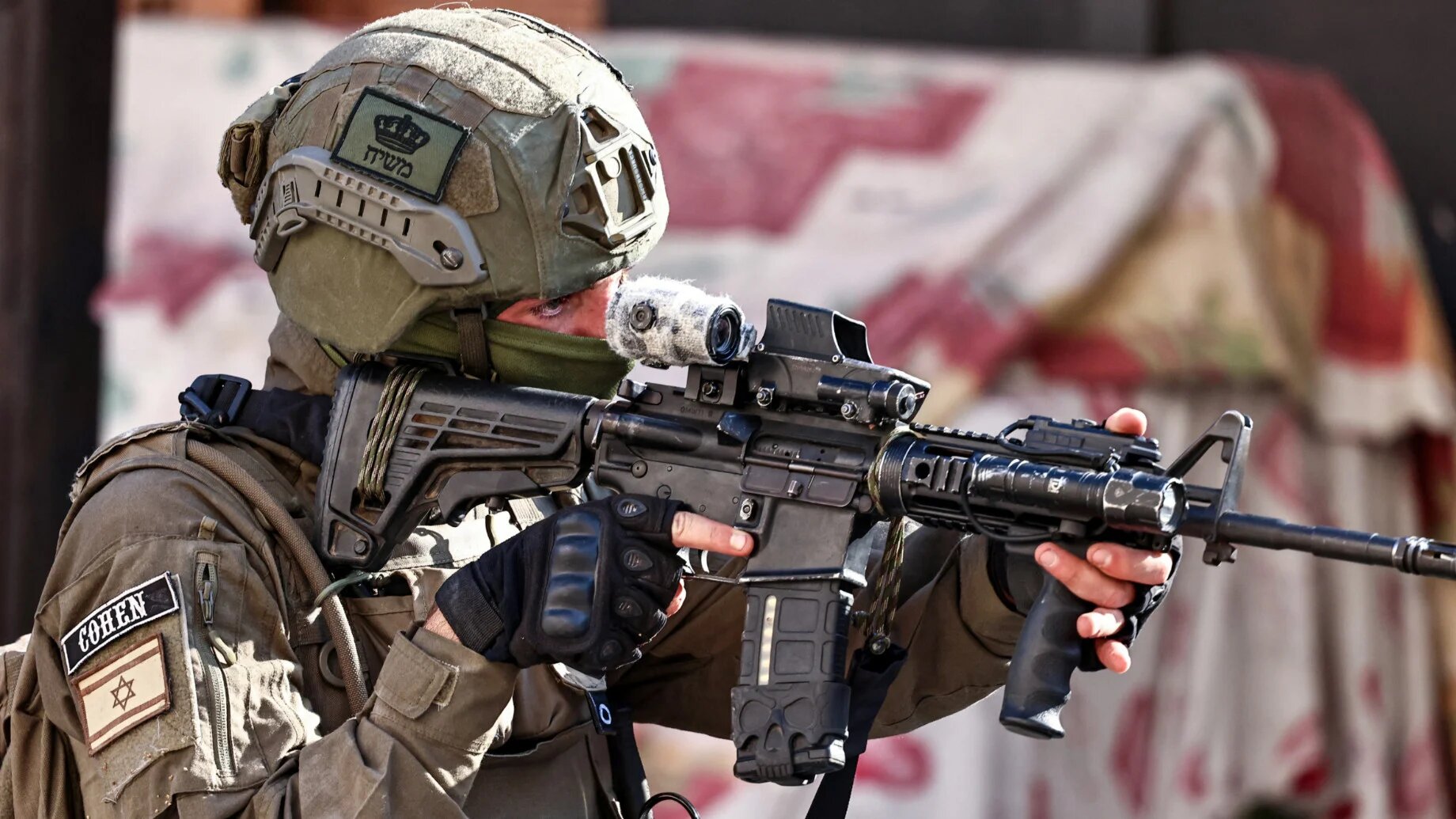 An Israeli soldier aims his rifle during a military operation in the town of Qalqilya, in the occupied West Bank, on 4 December 2025 (AFP)