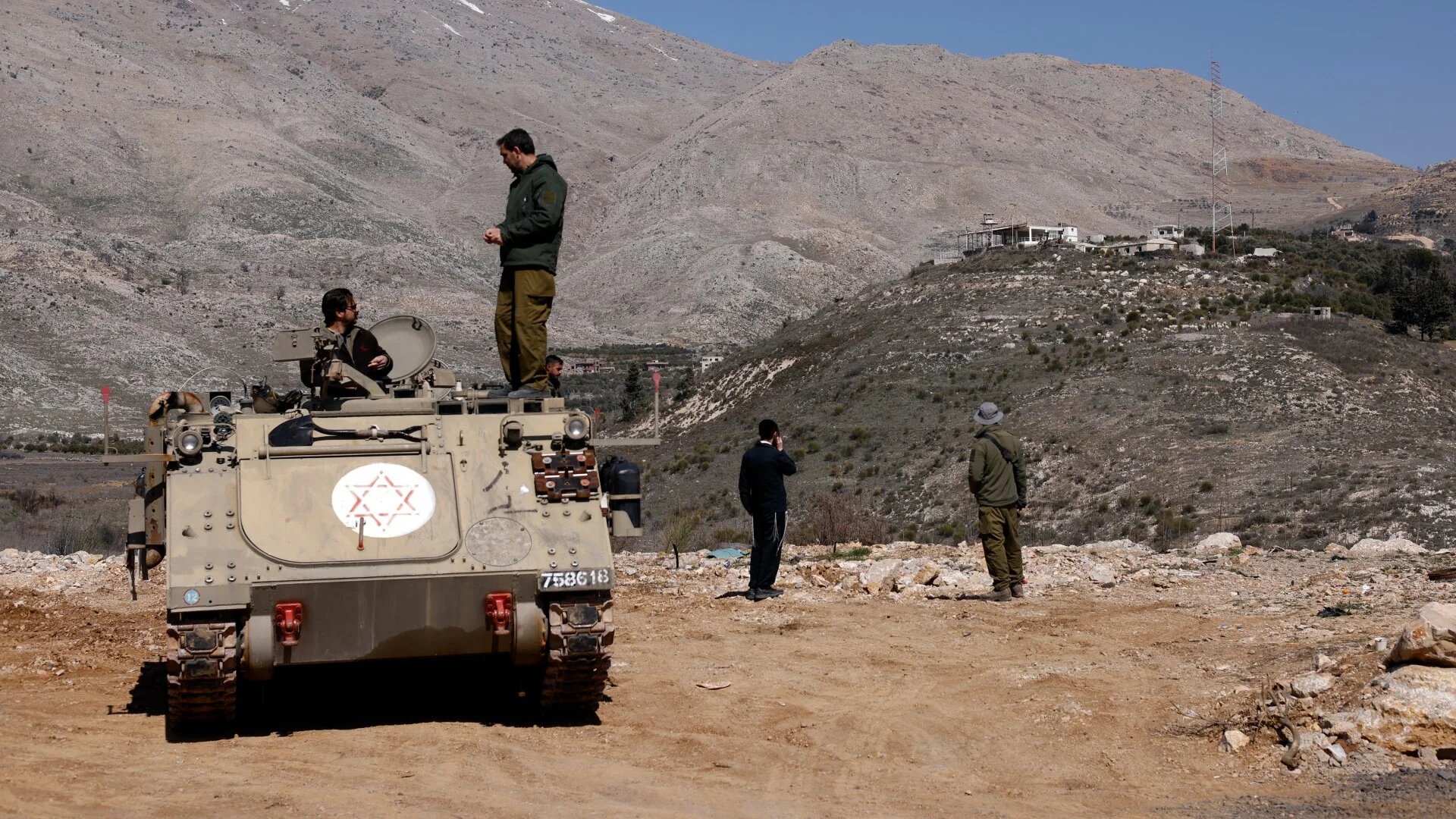Israeli soldiers stand atop an armoured personnel near the Druze village of Majdal Shams in the occupied Golan Heights on 27 February 2025 (AFP/Jalaa Marey)