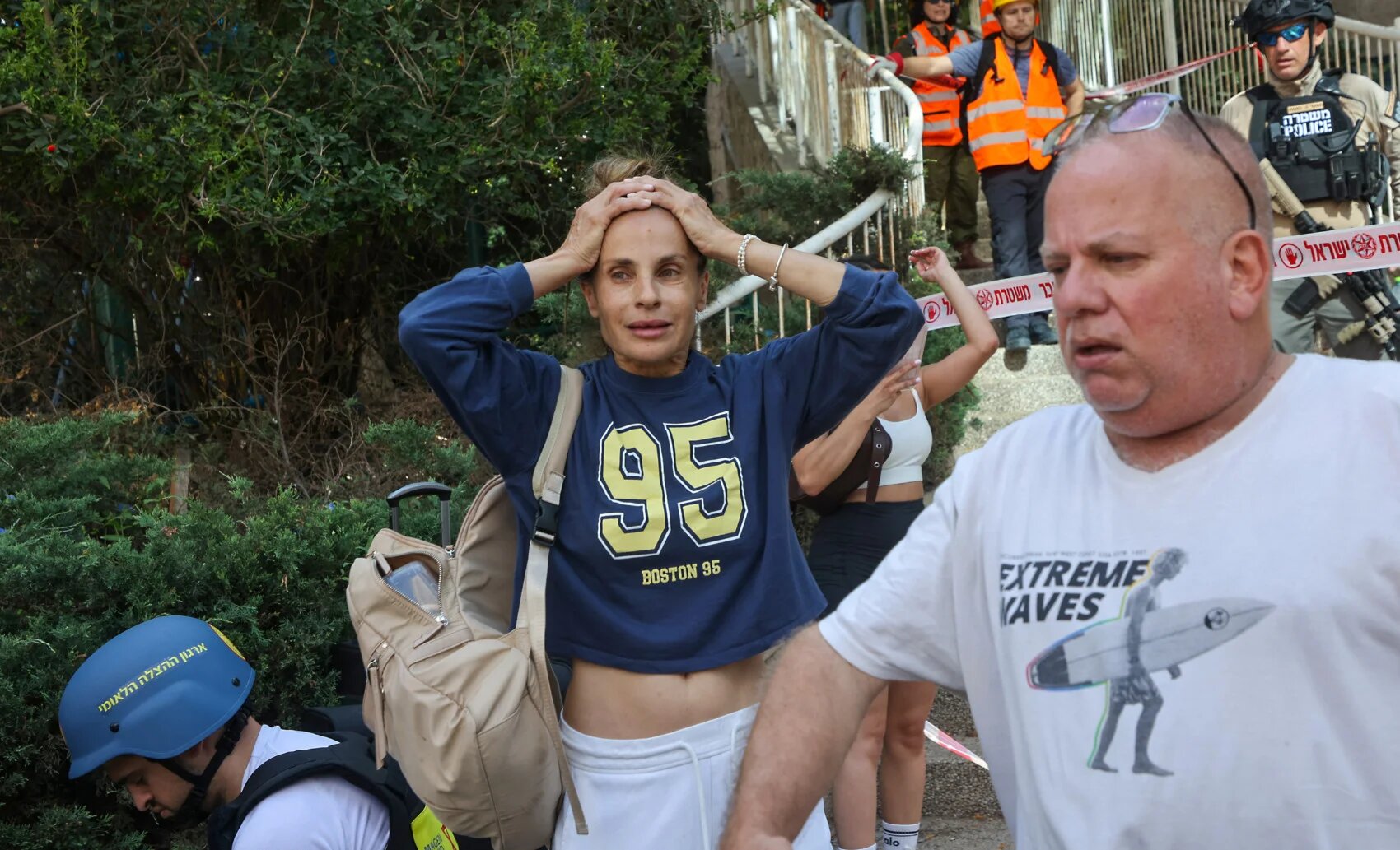 Civilians react as Israeli emergency services arrive at the site of an Iranian missile attack in Ramat Gan in central Israel near Tel Aviv, on 19 June 2025 (AFP)