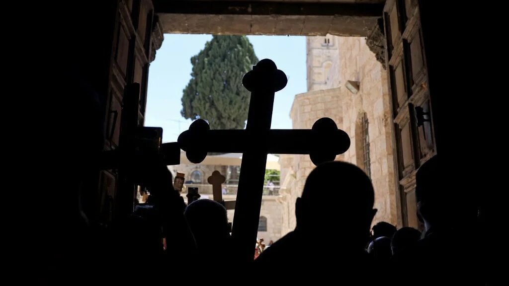 Christians carrying crosses walk through Jerusalem’s Old City on their way to the Church of the Holy Sepulchre on 18 April 2025 (Ahmad Gharabli/AFP)