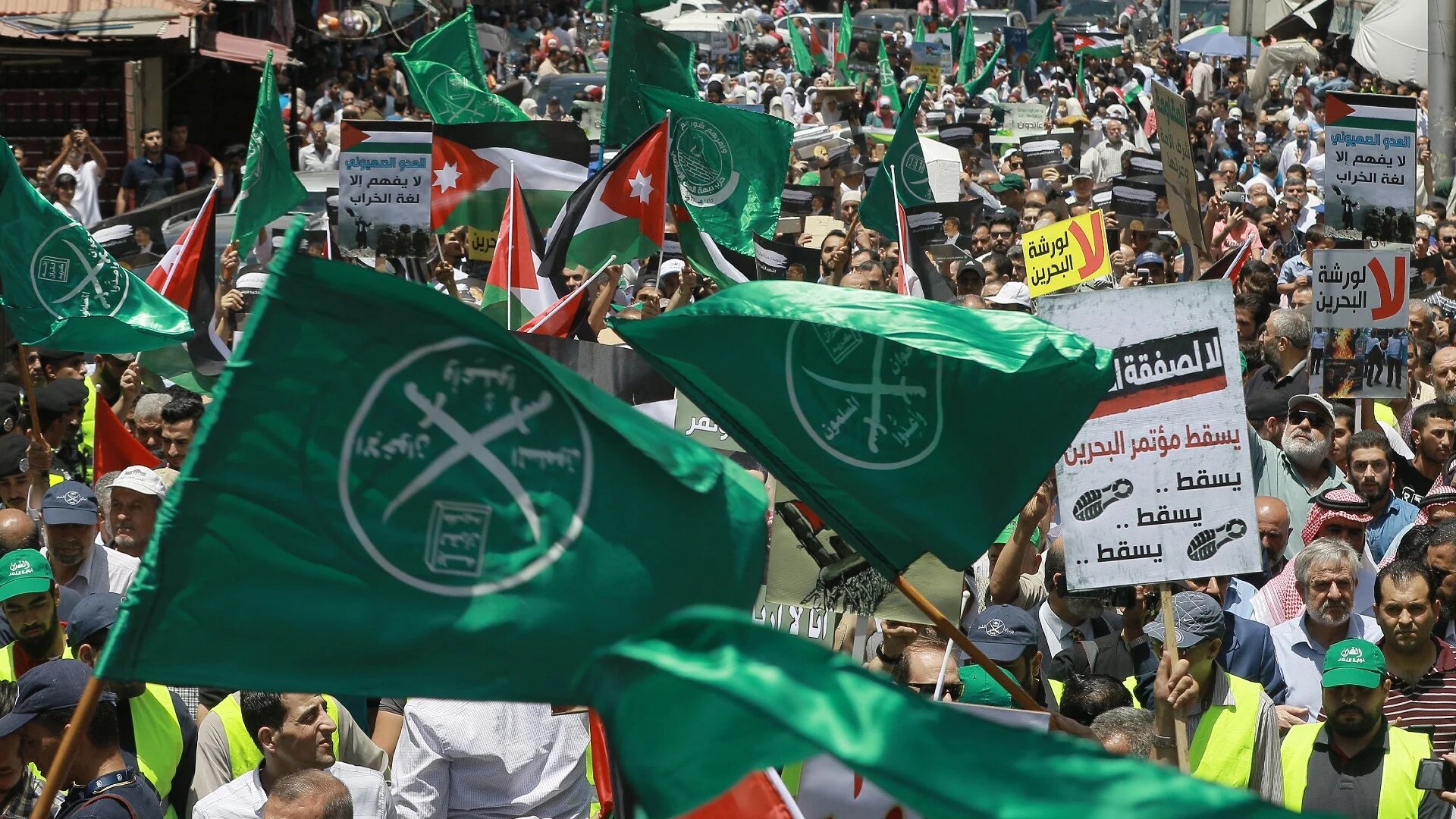 Protesters wave the flags of the Muslim Brotherhood in the Jordanian capital Amman on 21 June 2019 following US President Donald Trump's 'Deal of the Century' announcement (Khalil Mazraawi/AFP)