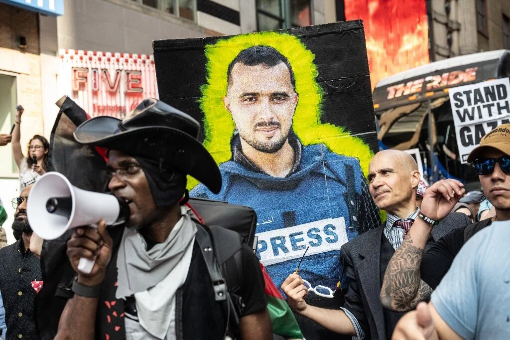 A person holds an image of a journalist killed in Gaza as Pro-Palestinian protesters participate in a "March for Humanity" against the humanitarian crisis in Gaza on 16 August, 2025 in New York City. (Stephanie Keith/Getty Images/AFP)