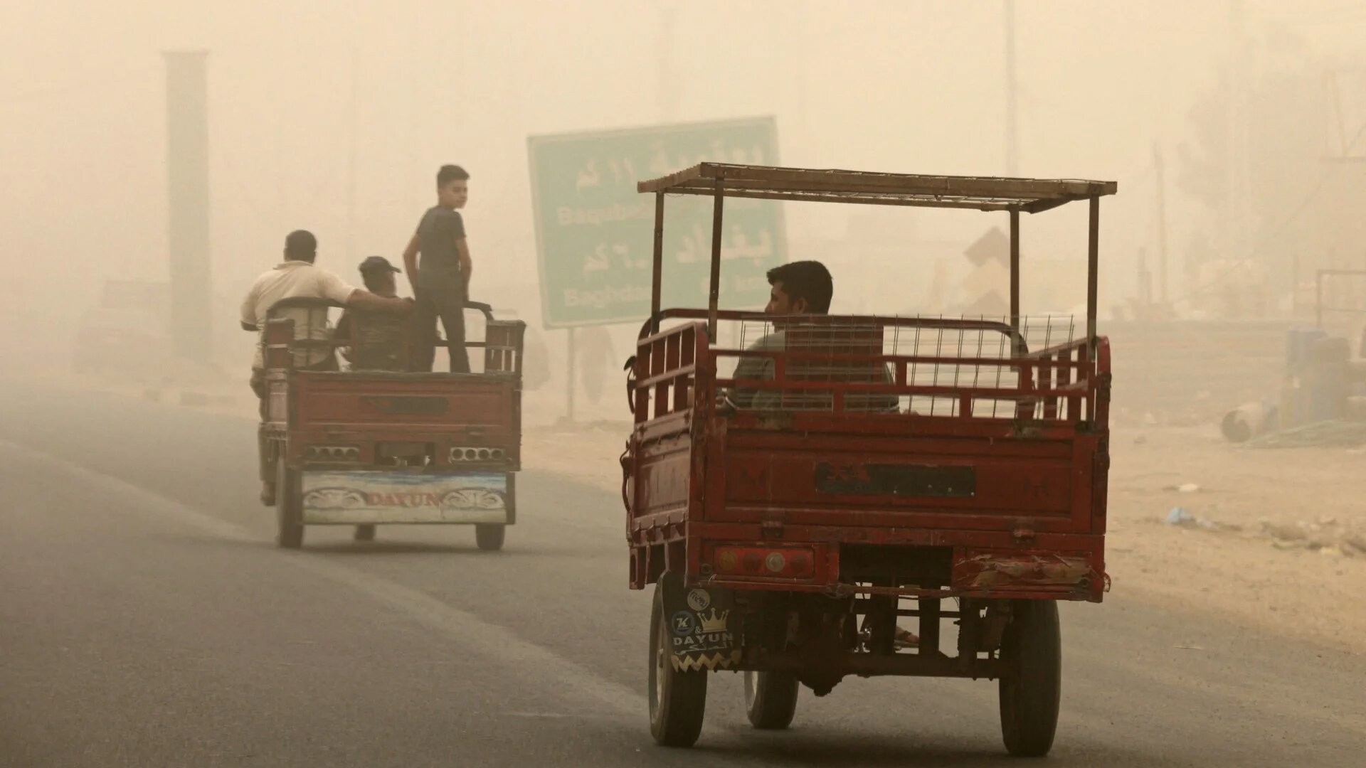 People ride in vehicles in the town of Khalis, in Iraq's Diyala province, on 3 July 2022 (AFP)