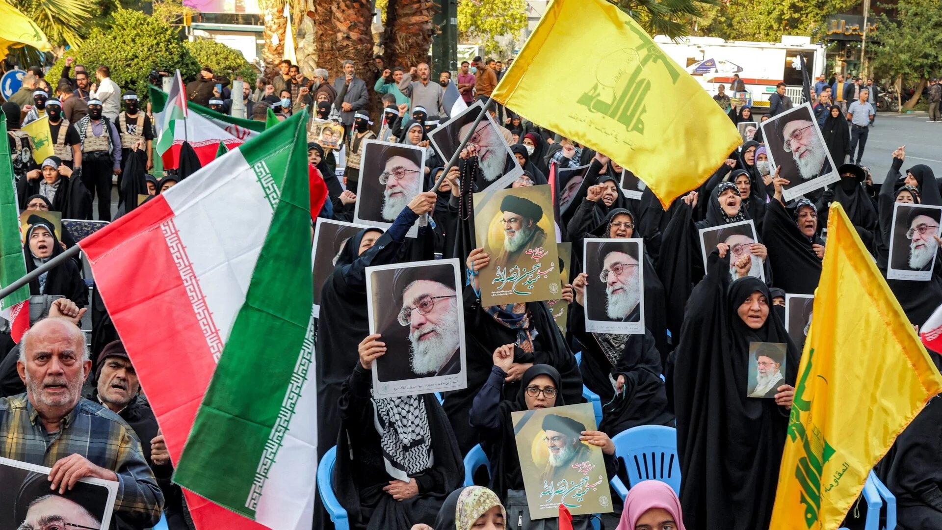 Demonstrators wave flags of Iran and Hezbollah, and pictures of Iran's Supreme Leader Ayatollah Ali Khamenei and the slain Hezbollah Leader Hassan Nasrallah, during a rally in Tehran on 24 October 2024 (AFP)