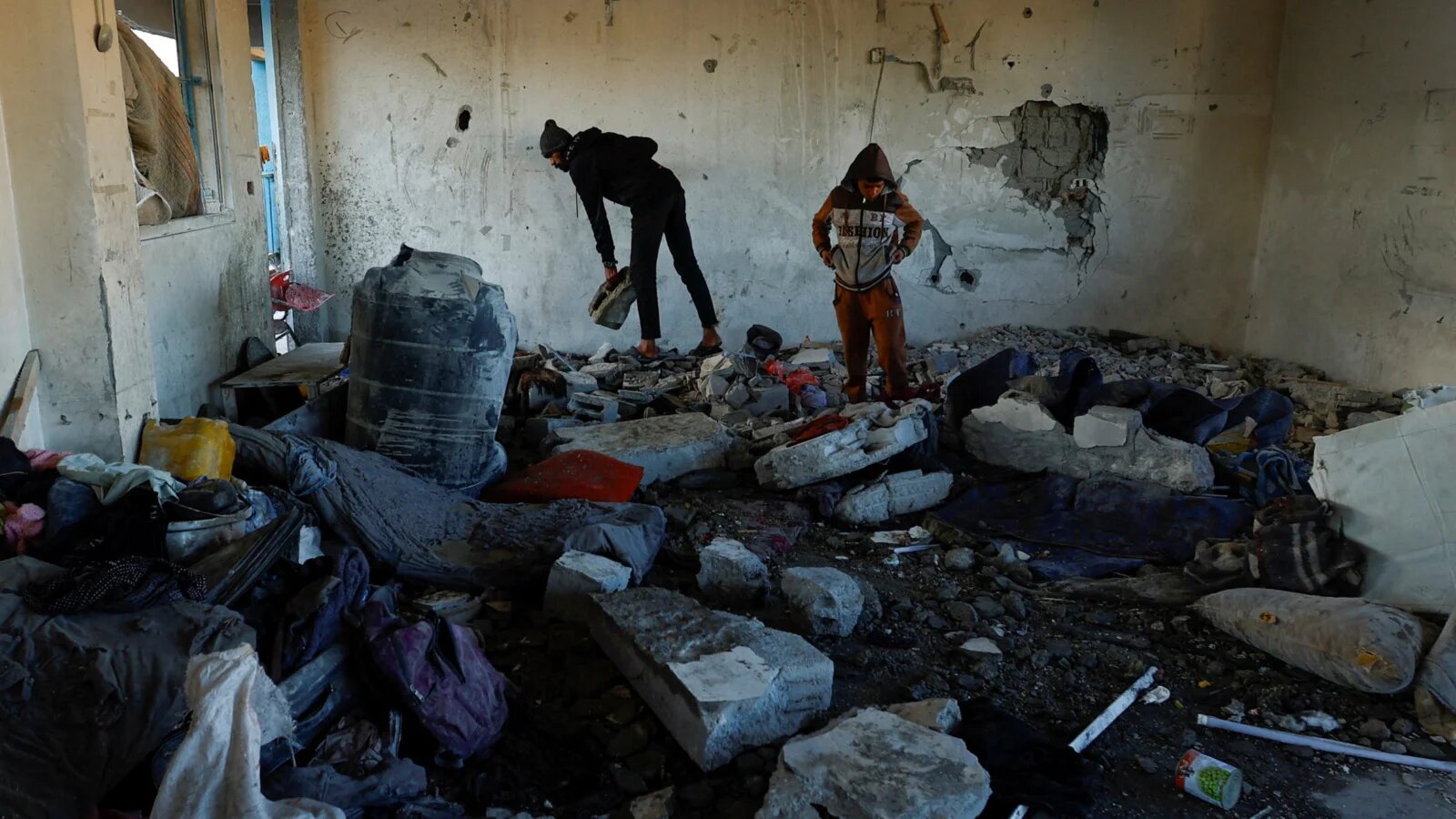 Palestinians inspect the damage in the aftermath of an Israeli strike on a school sheltering displaced people in Khan Younis, southern Gaza Strip on 16 December 2024 (Mohammed Salem/Reuters)
