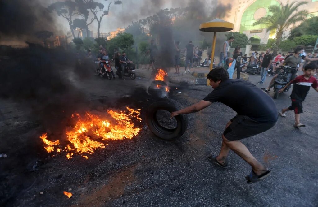 Lebanese youths burn tyres to block a main highway east of the capital Beirut, as they protest against the country's dire living conditions on 24 June 2021